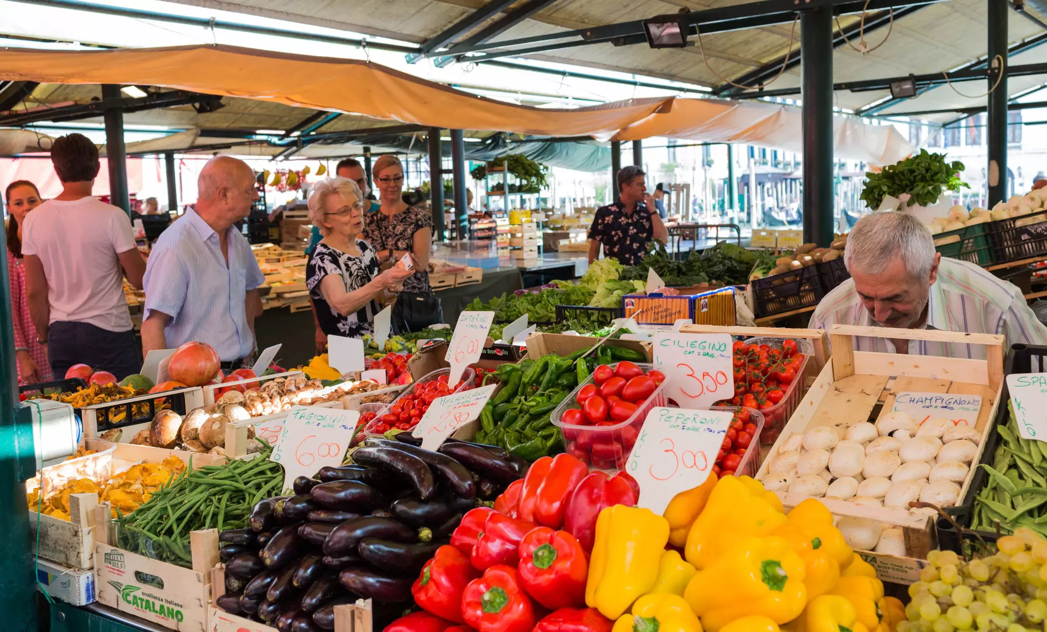 Rialto fish markets. Vegetables, fruits are on counter. Customers Buy Products.