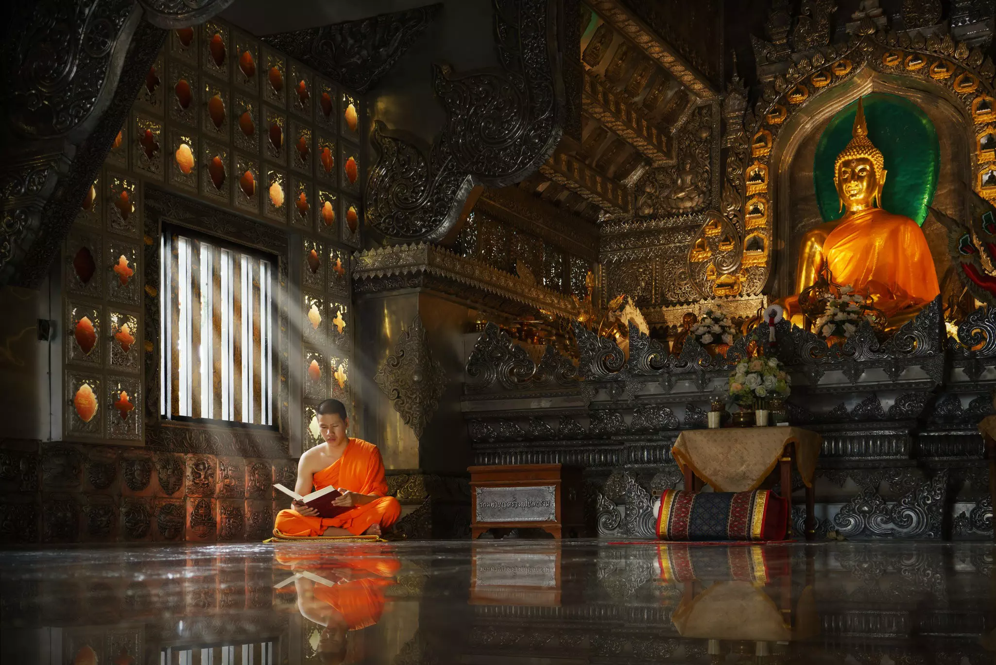 Young novice Buddhist monk reading inside a Chaing Mai monastery. ©Sangkhom Simma/Getty Images