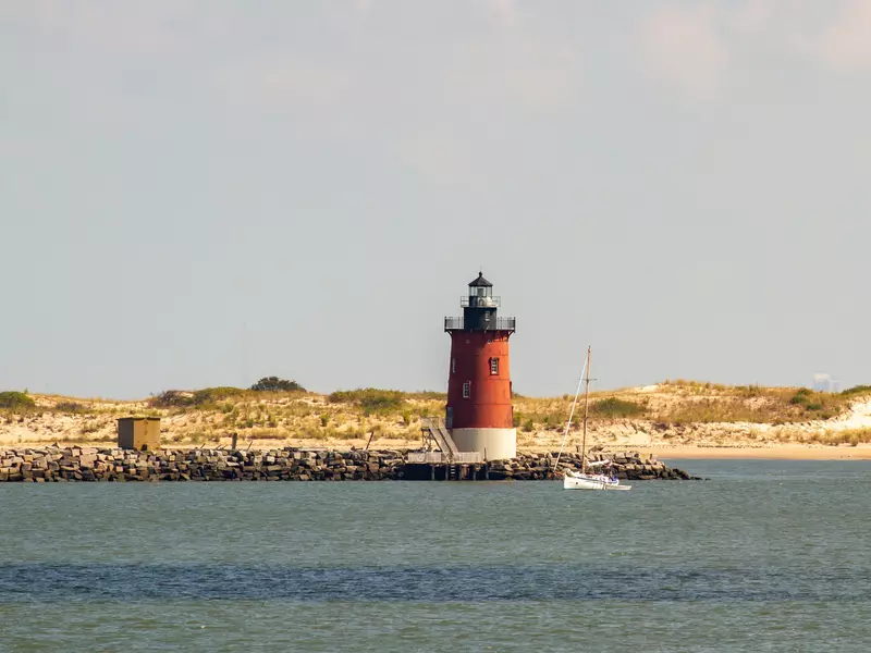 Delaware Breakwater East End Lighthouse and sailboat off the coast of Lewes, Delaware 