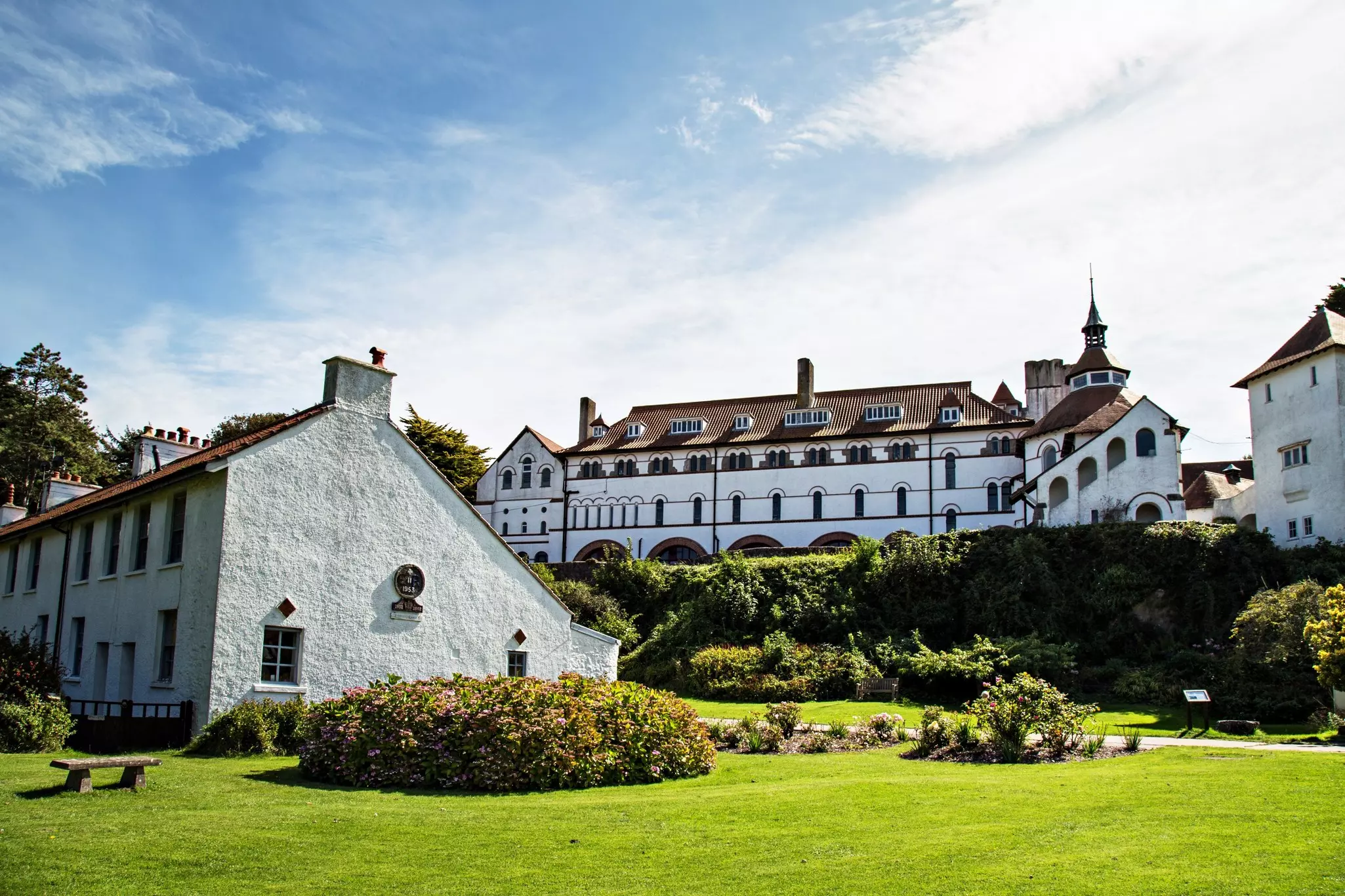 An Italian-style monastery and village green on a sunny day