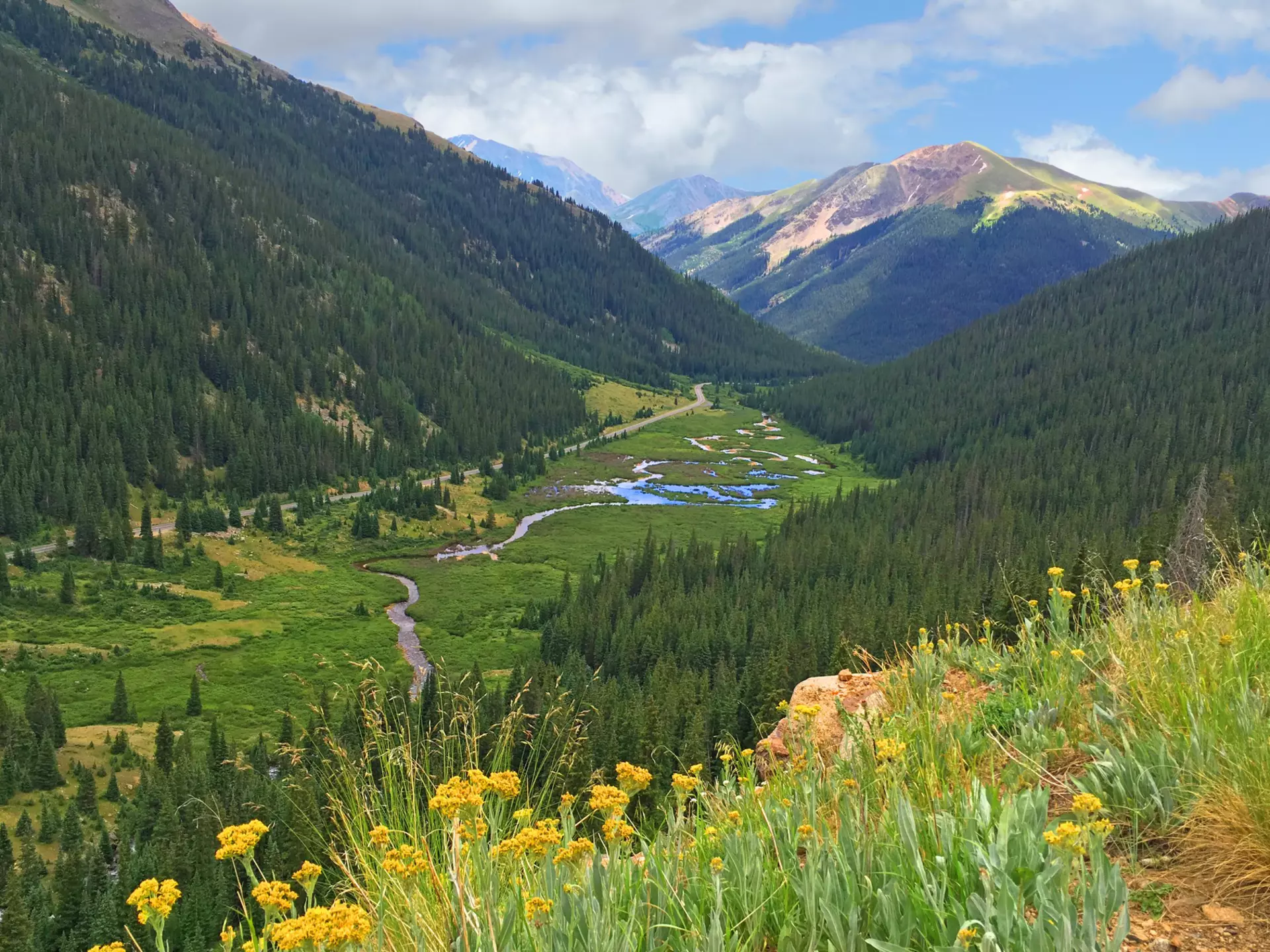 A sweeping, verdant meadow with water running through its valley