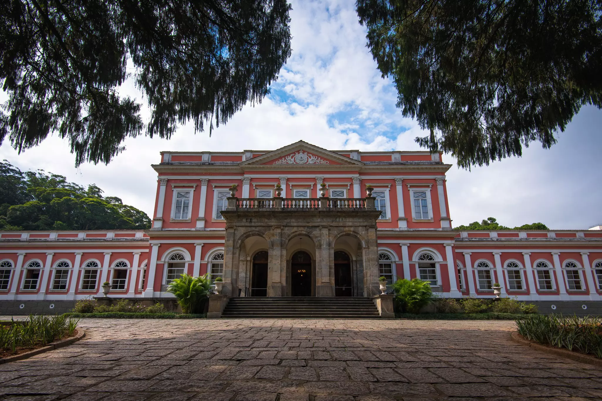 Ground-up view of a large pink mansion.