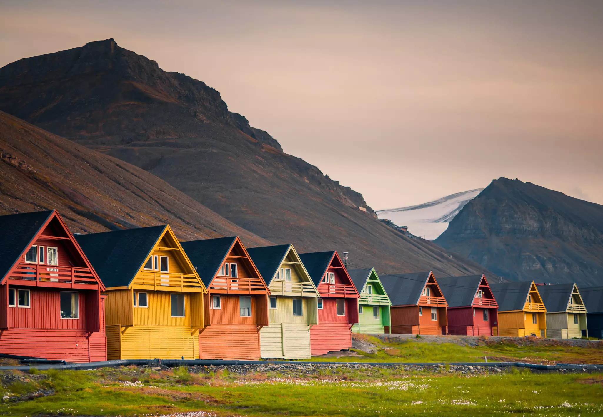 A row of colorful homes in Longyearben with mountains behind them