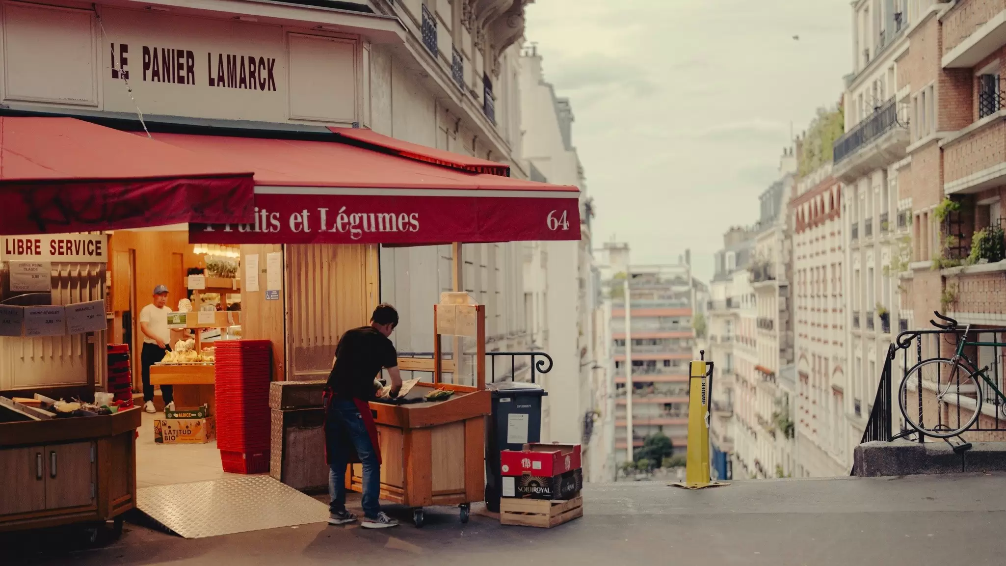 A man at a food stall outside a store in Montmartre and Northern Paris, Rue Caulaincourt, Paris, France.