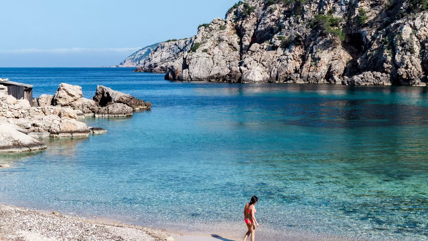 A woman checks the water at the secluded Cala d’en Serra beach on Ibiza’s northern shore.