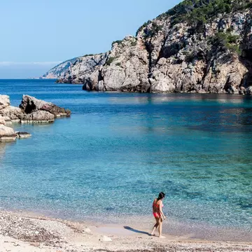 A woman checks the water at the secluded Cala d’en Serra beach on Ibiza’s northern shore.
