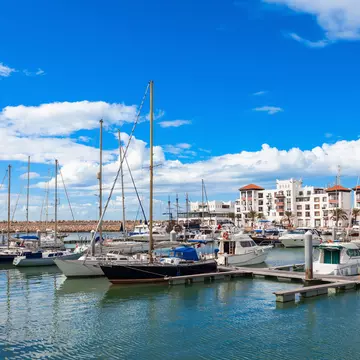Boats at the marina in Agadir with white buildings in the background