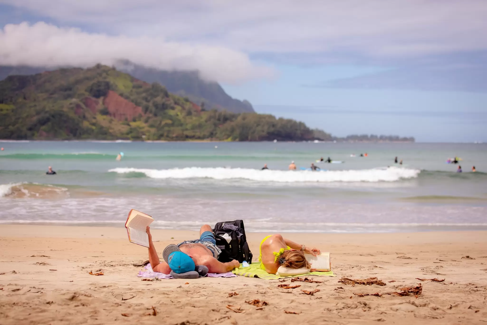 Reading on the beach in Hanalei Bay, Kaua'i. bluestork/Shutterstock