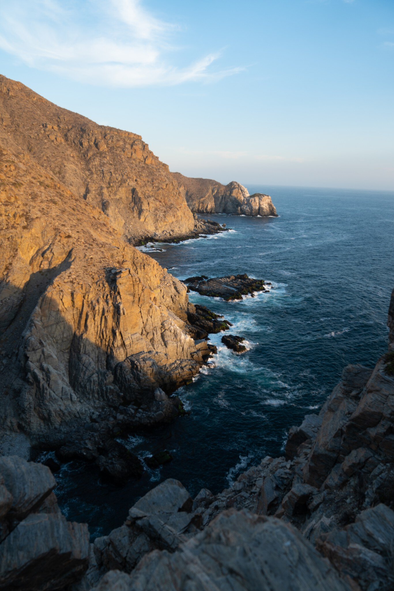 Scenic view of rugged cliffs meeting the ocean at Punta Lobos, Baja California, under a clear blue sky during sunset., License Type: media, Download Time: 2026-01-21T16:23:37.000Z, User: LP_YKhanna, Editorial: false, purchase_order: 65050 - Digital Destinations and Articles, job: LP, client: App Content, other: Yuvraj Khanna