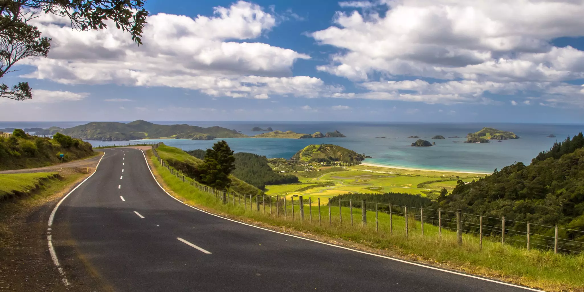 A road goes by the coastline on a cloudy day.