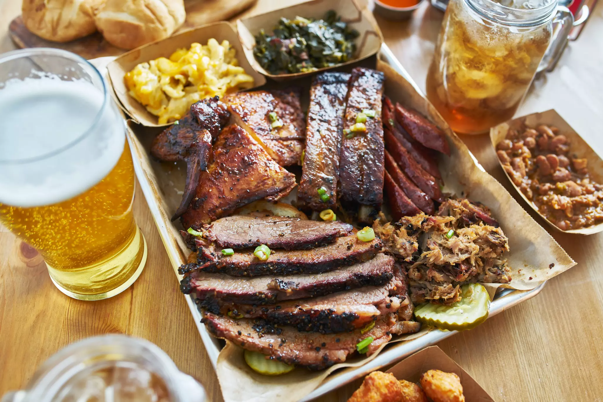 Texas style bbq tray with smoked brisket, st louis ribs, pulled pork, chicken, hot links and sides.