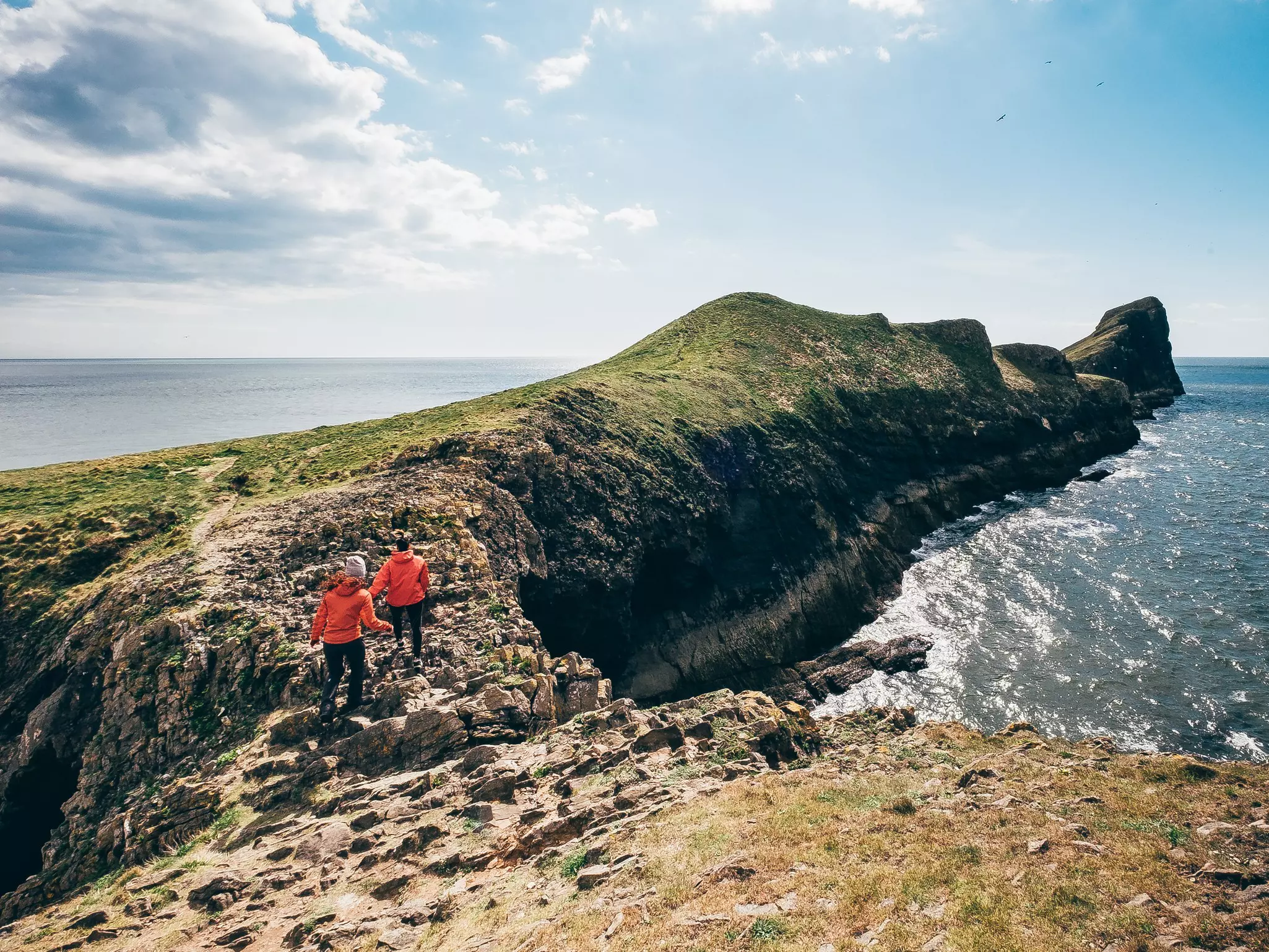 Girls hiking the Worm's Head hiking trail at Rhossili Bay, Gower Peninsula, Wales.