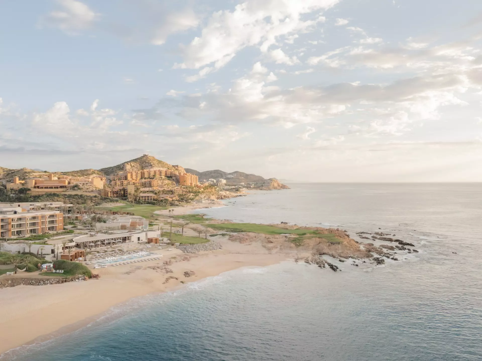 A golden sandy beach with a hotel complex.