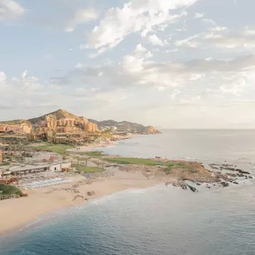 A golden sandy beach with a hotel complex.