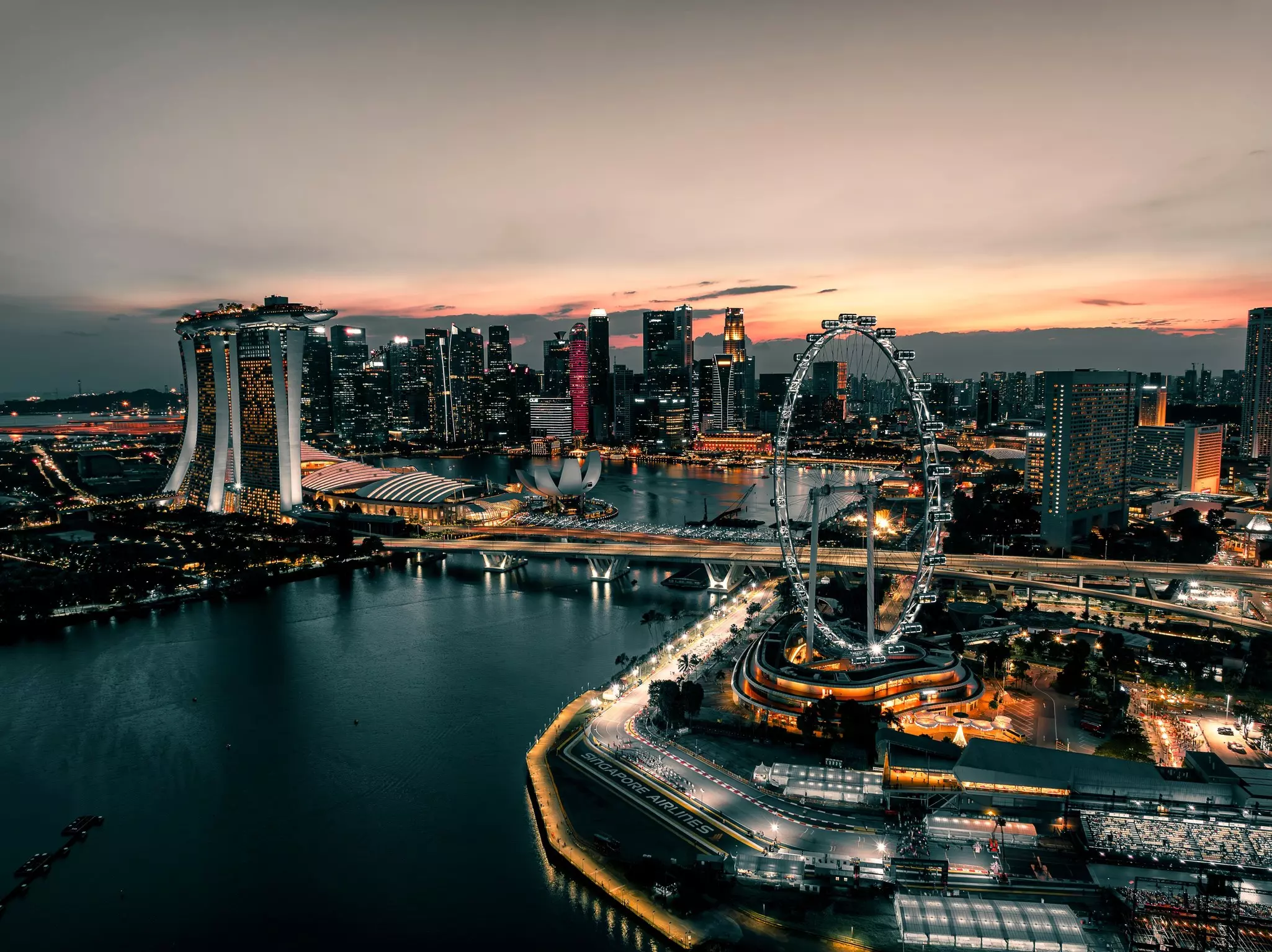 Roads and buildings around a bay are lit up at night.