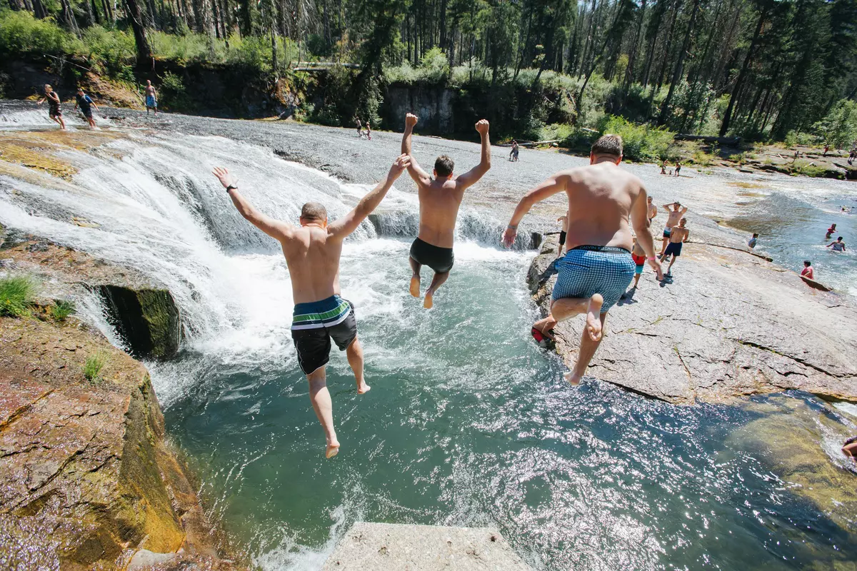 PORTLAND, USA - JUNE 20 2017: Three men are jumping into the lake