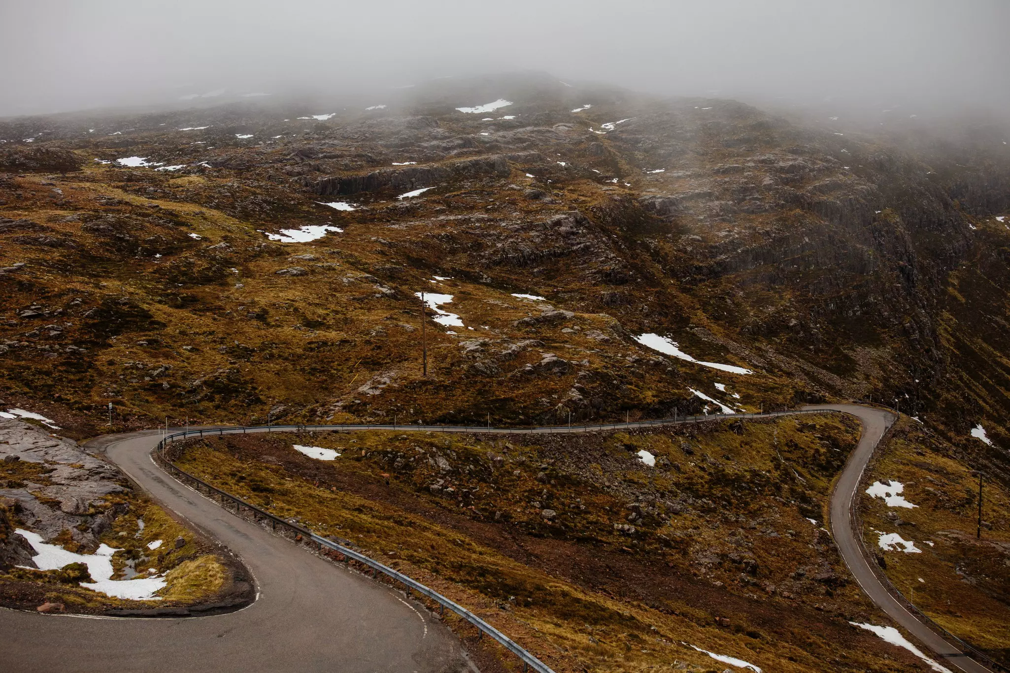 Aerial view with a foggy sky over the Bealach na Bà, a winding, single-track road that passes through the Applecross peninsula