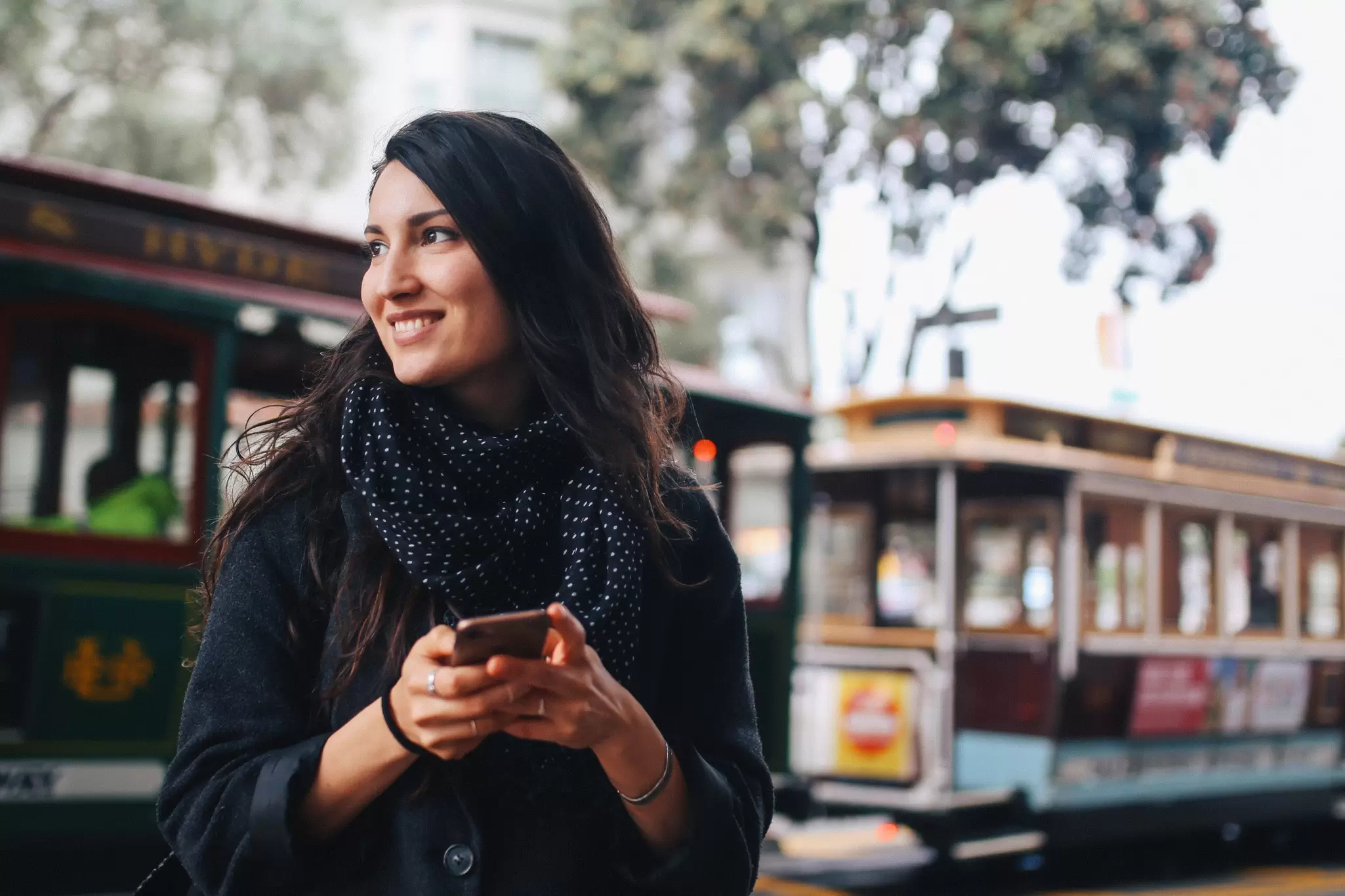 A woman using her phone on a street in San Francisco