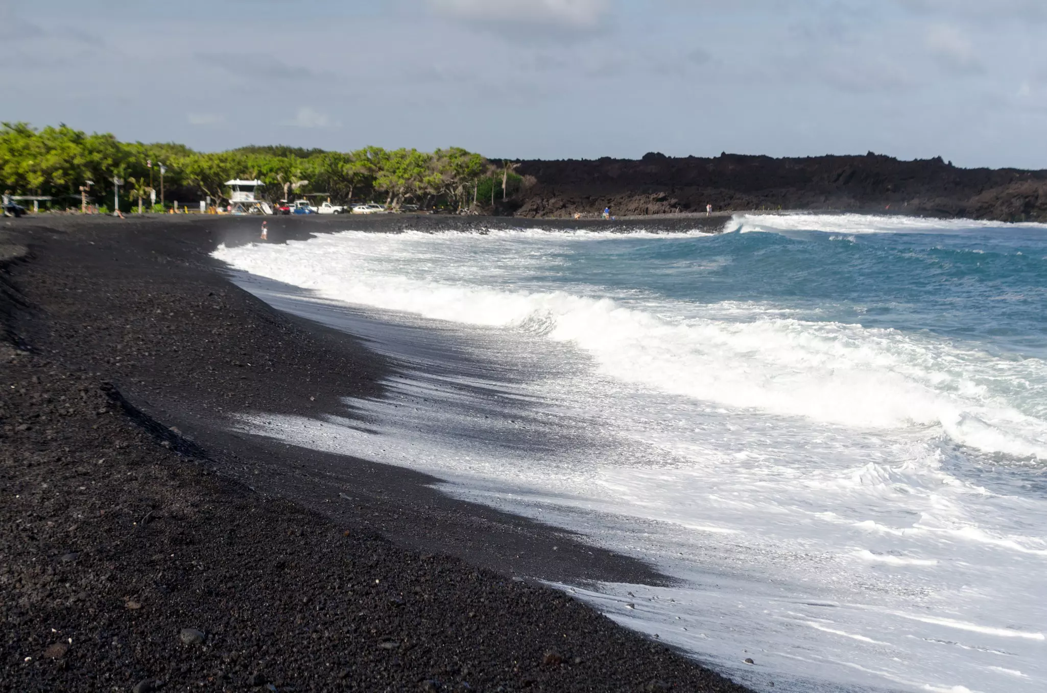 Rough surf  at edge of black sands of Pohoiki  beach, Isaac Hale Beach Park, Big Island.