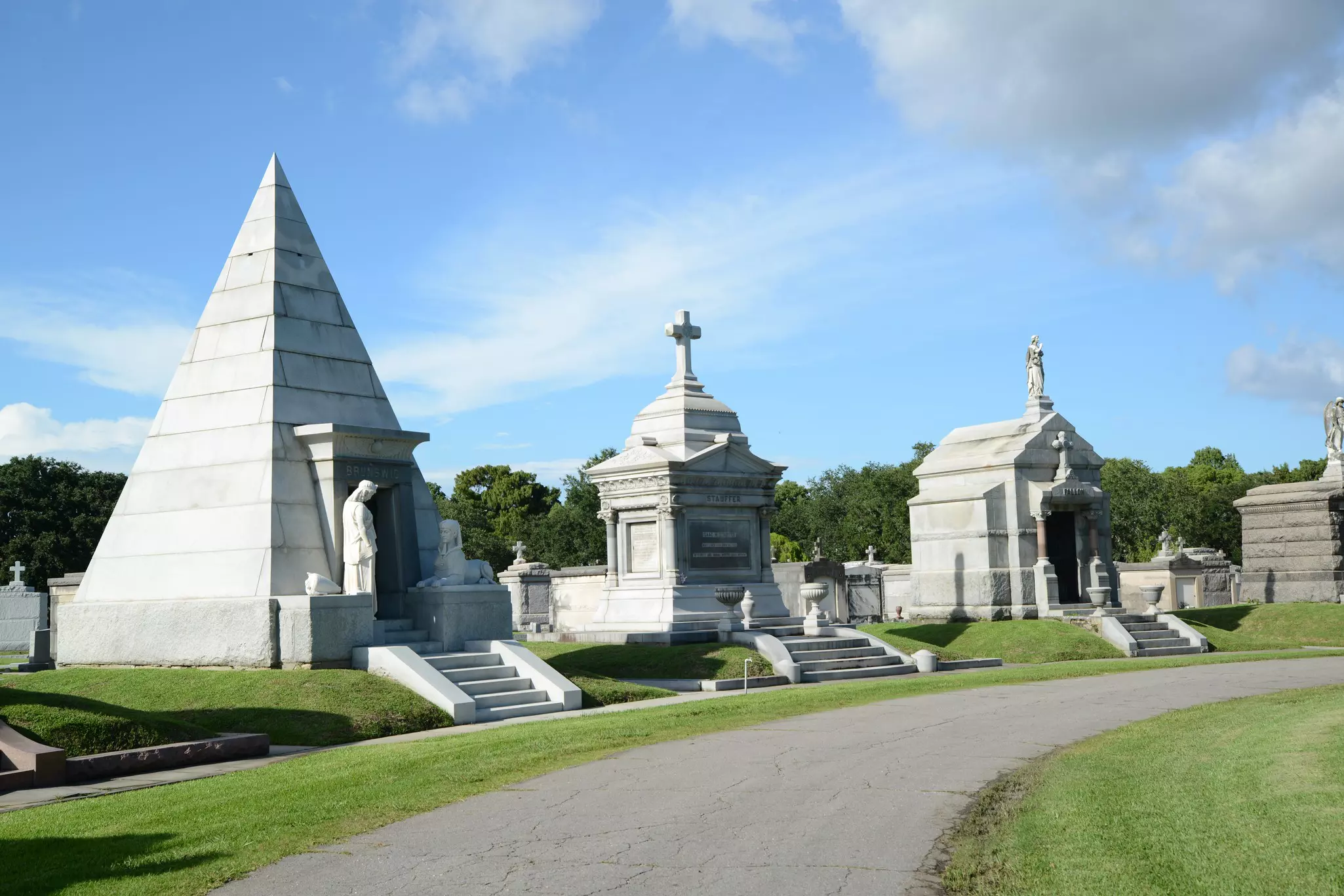 Large stone mausoleums in grassland at Metairie Cemetery, New Orleans. 