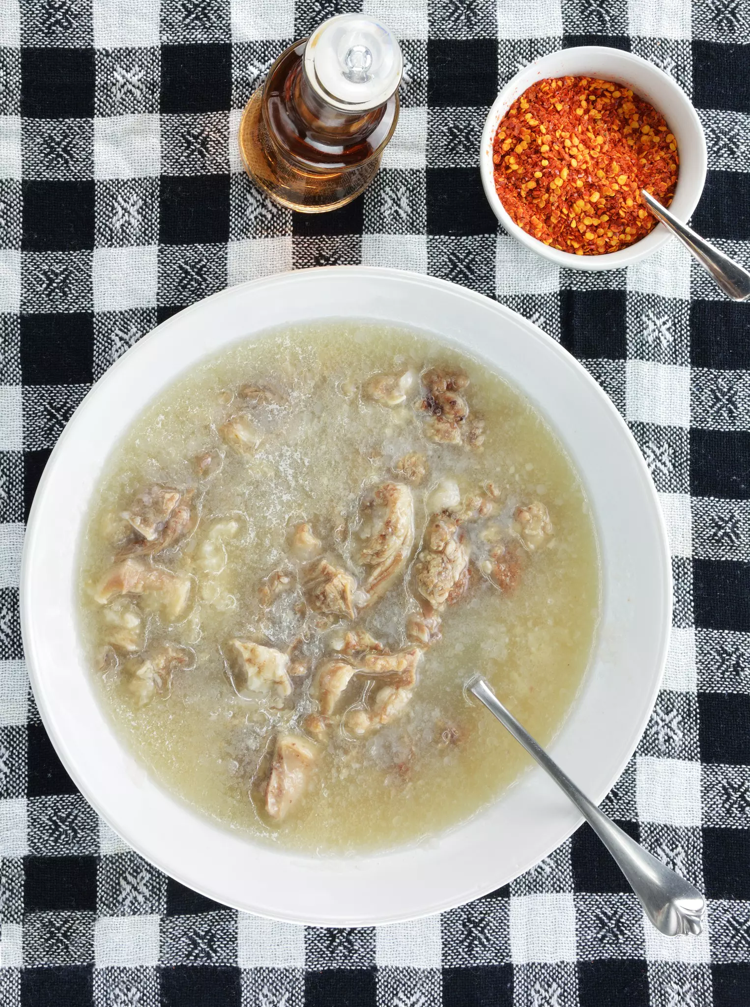 A bowl of soup on a black-and-white checked tablecloth