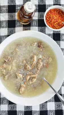 A bowl of soup on a black-and-white checked tablecloth
