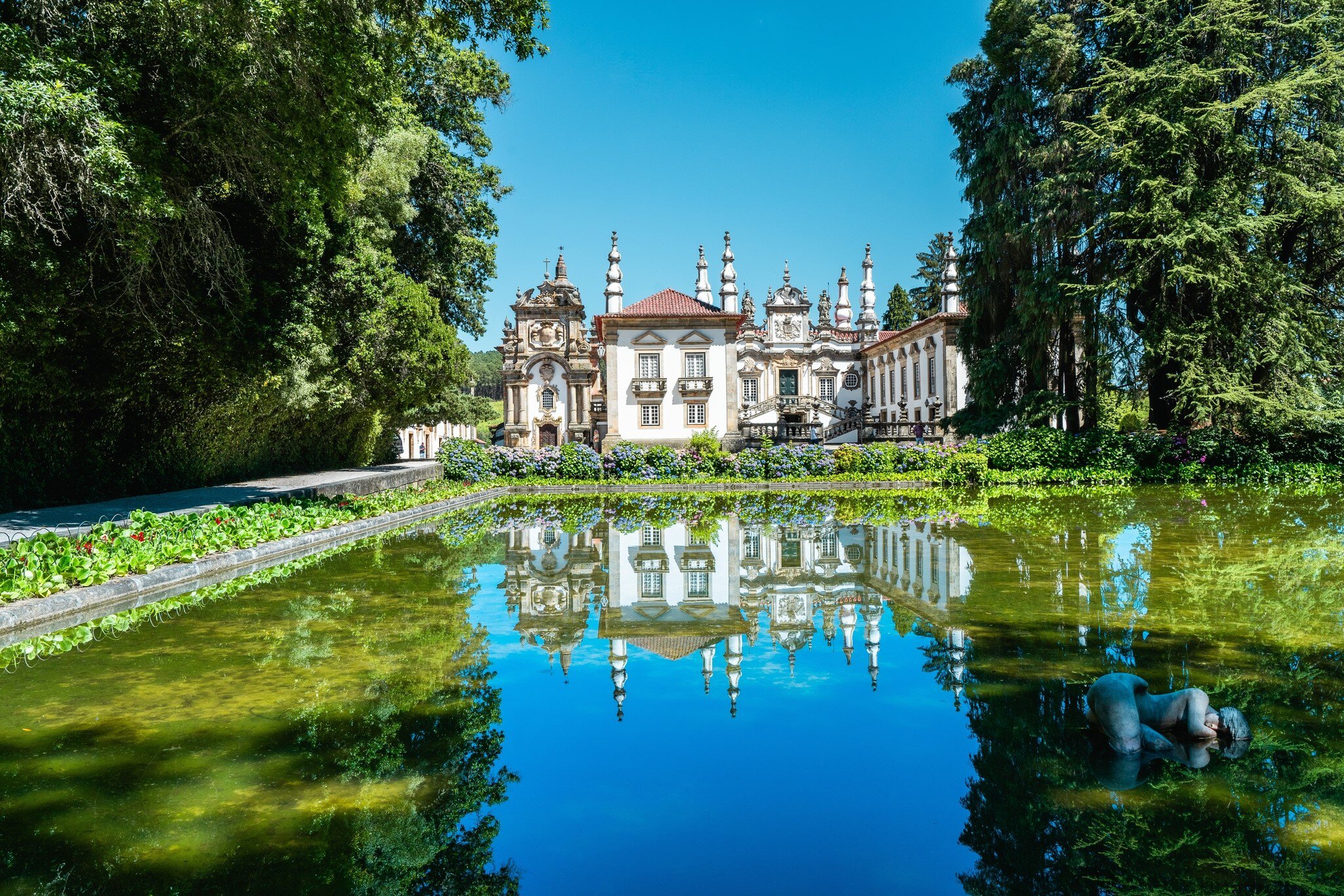 View of the Casa de Mateus in the Douro Valley, Portugal, with a pond in the foreground.