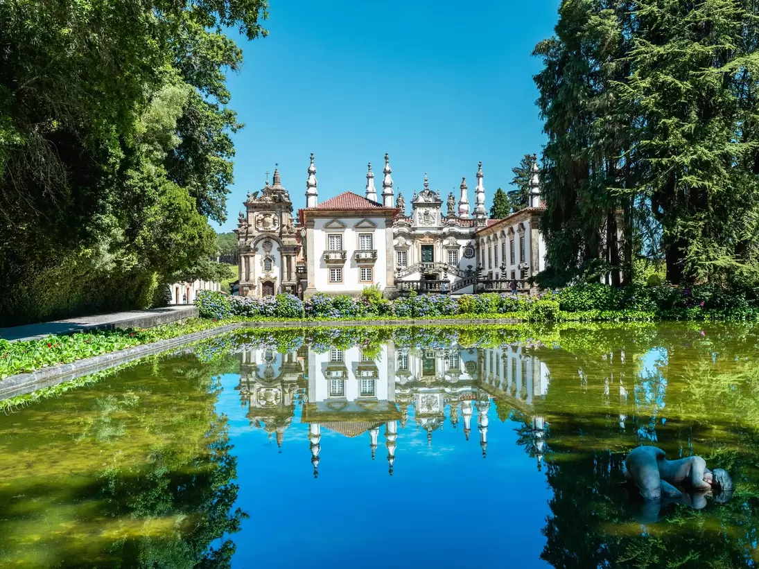 View of the Casa de Mateus in the Douro Valley, Portugal, with a pond in the foreground.