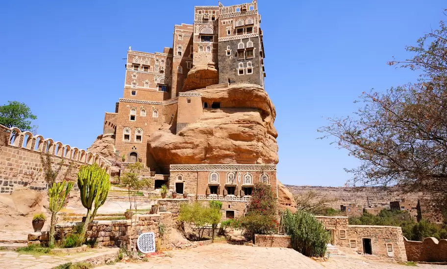 Dar al-Hajar, Yemen: multistorey palace of mud brick with white lattice windows built atop a huge sandstone rock