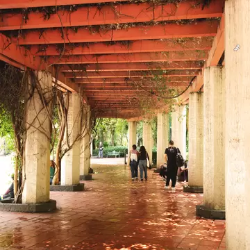 People walk under a colonnade. 