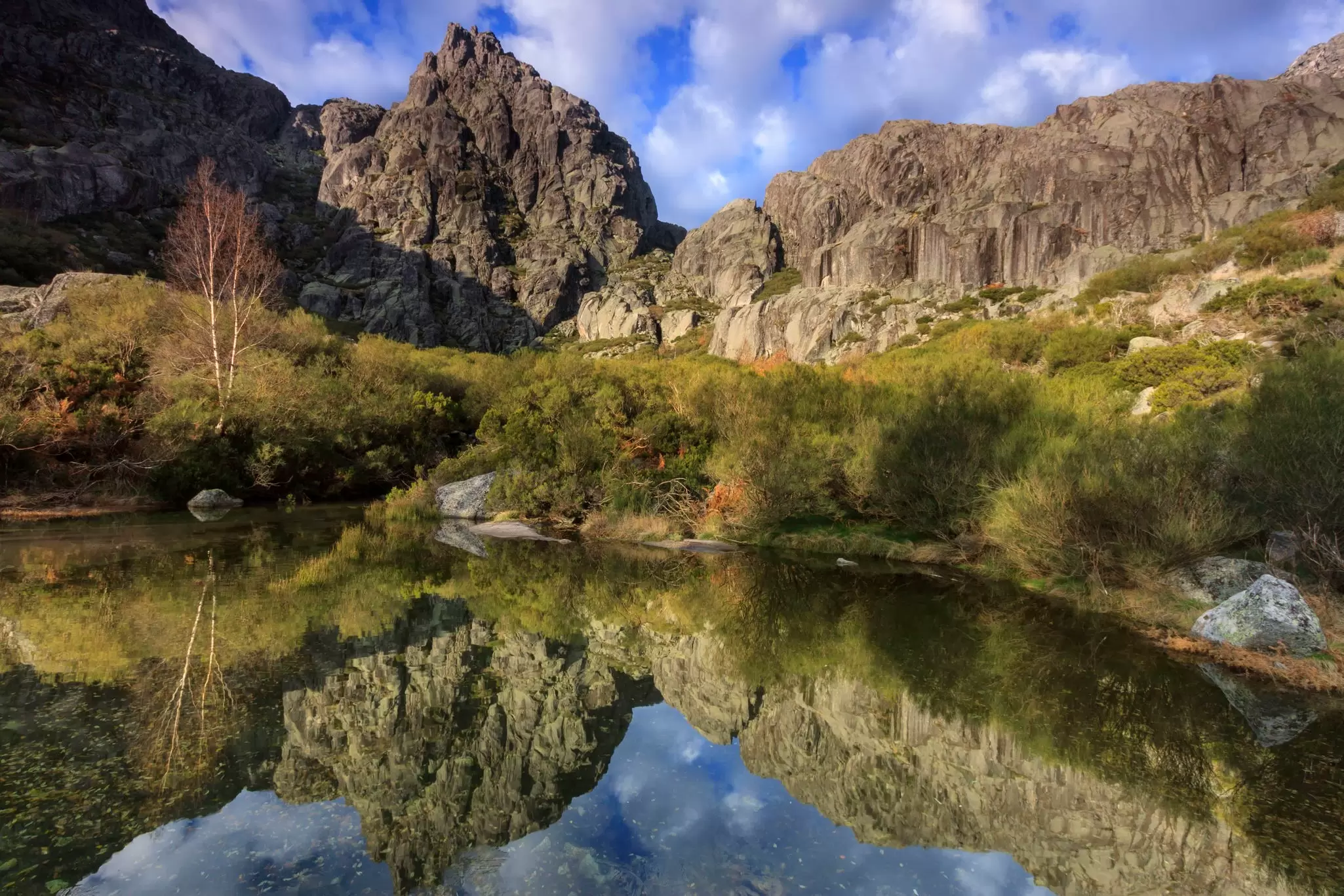 Jagged peaks and a glacial lake in the Parque Natural da Serra da Estrela. ARoxo / Getty Images