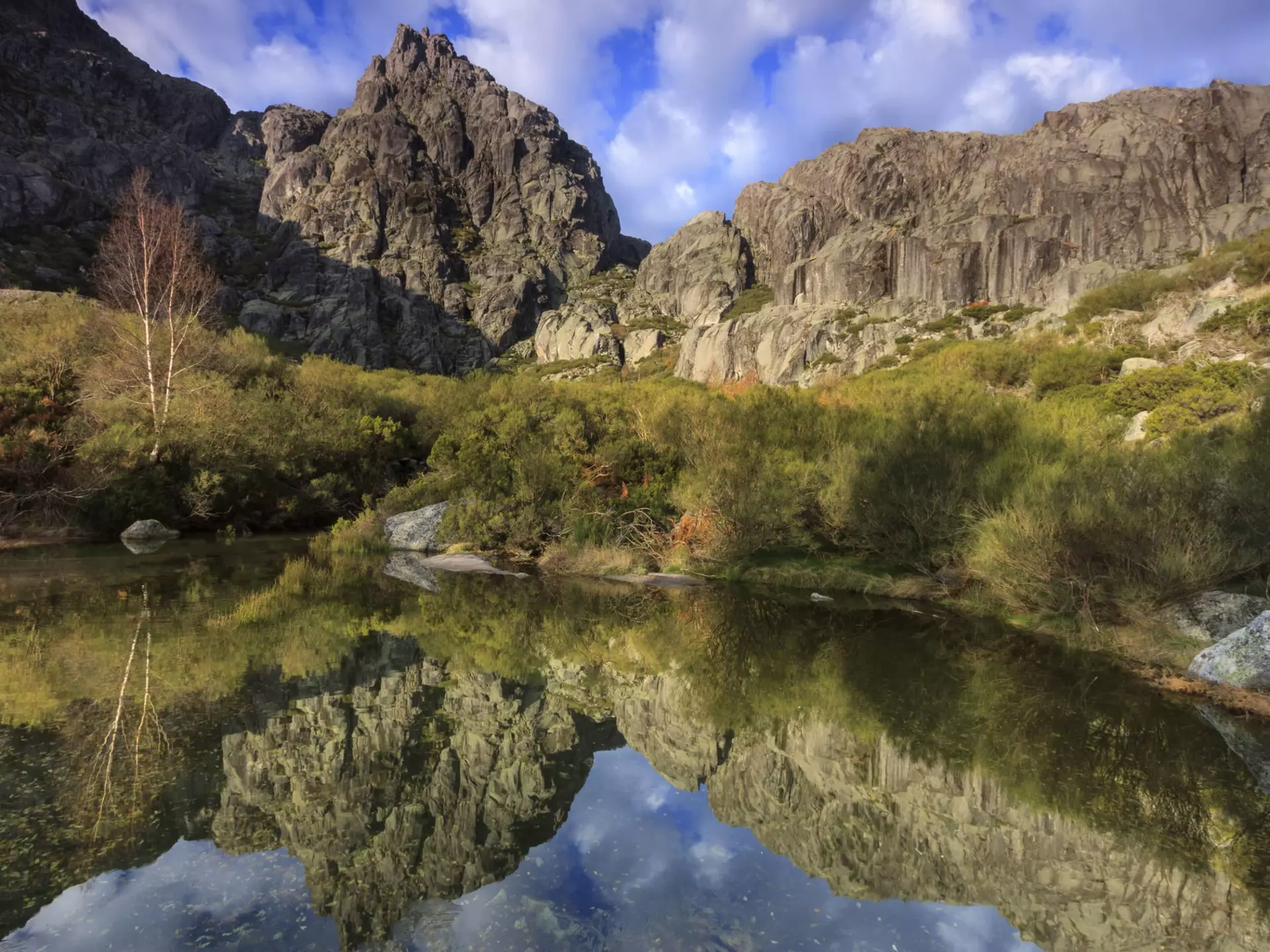 Jagged peaks and a glacial lake in the Parque Natural da Serra da Estrela. ARoxo / Getty Images