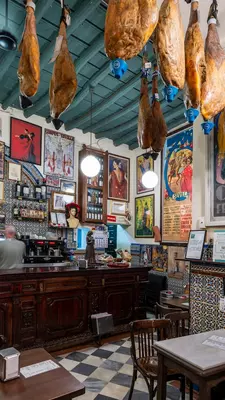 Interior of a restaurant with framed posters and tiled walls.
