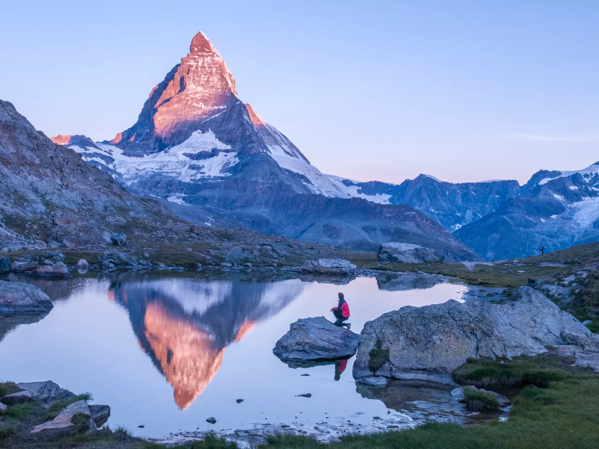 Early morning dawn scene of sunrise on the Matterhorn Mountain reflecting pink in the lake with male man on rock with red down jacket with clear blue sky Gornergrat Zermatt Matterhorn Europe
808144682
panoramic, nature, outdoors, Matterhorn, Switzerland, hike, hiking, hiker, sunrise, Swiss Alps, Europe hiking, Gornergrat Zermatt