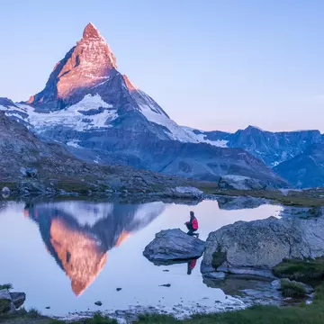 Early morning dawn scene of sunrise on the Matterhorn Mountain reflecting pink in the lake with male man on rock with red down jacket with clear blue sky Gornergrat Zermatt Matterhorn Europe
808144682
panoramic, nature, outdoors, Matterhorn, Switzerland, hike, hiking, hiker, sunrise, Swiss Alps, Europe hiking, Gornergrat Zermatt