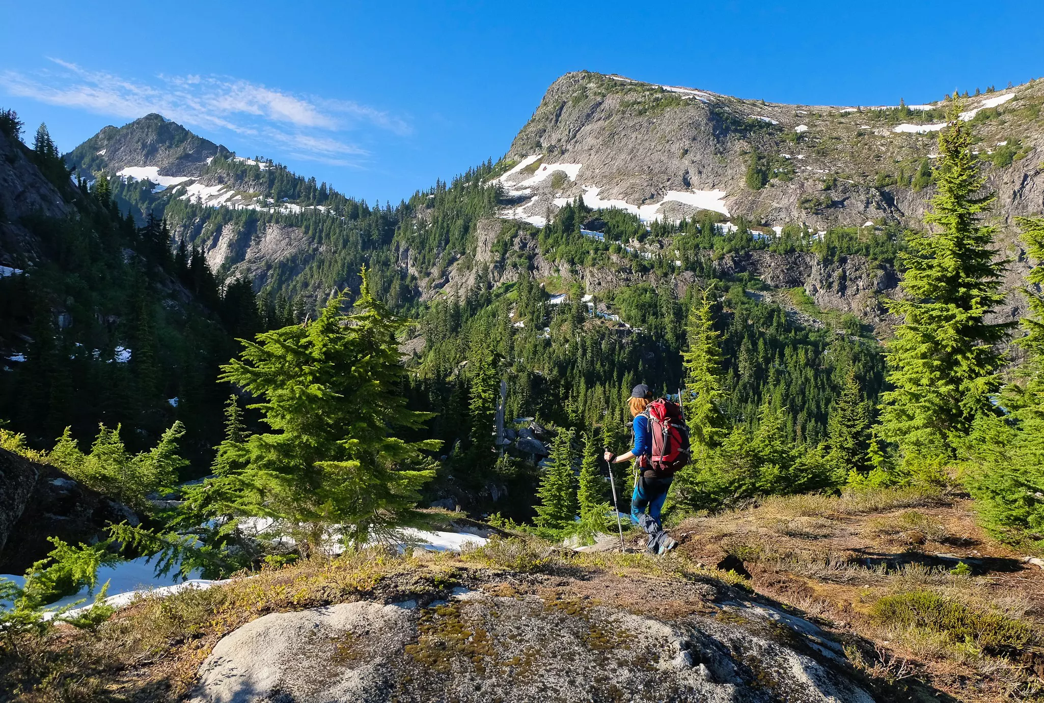 A hiker walking through North Cascades National Park, Washington, in summer.