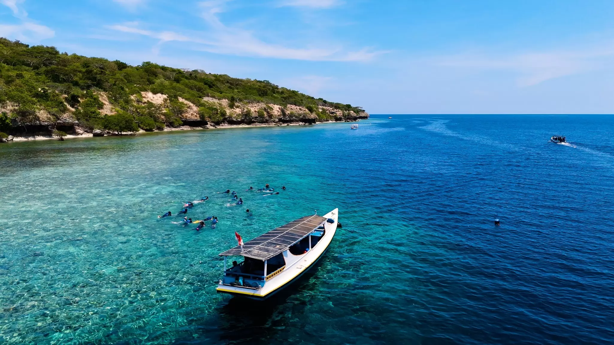 Aerial view of boats passing by Menjangan Island in Indonesia.