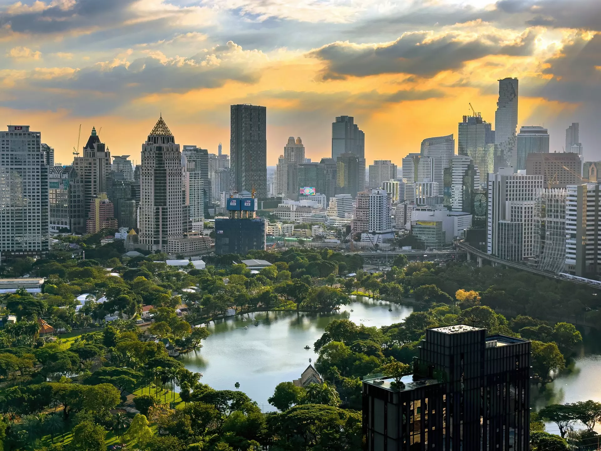  Scenic view of downtown Bangkok with Lumpini park surrounded by high rises at sunset, Thailand, Southeast Asia