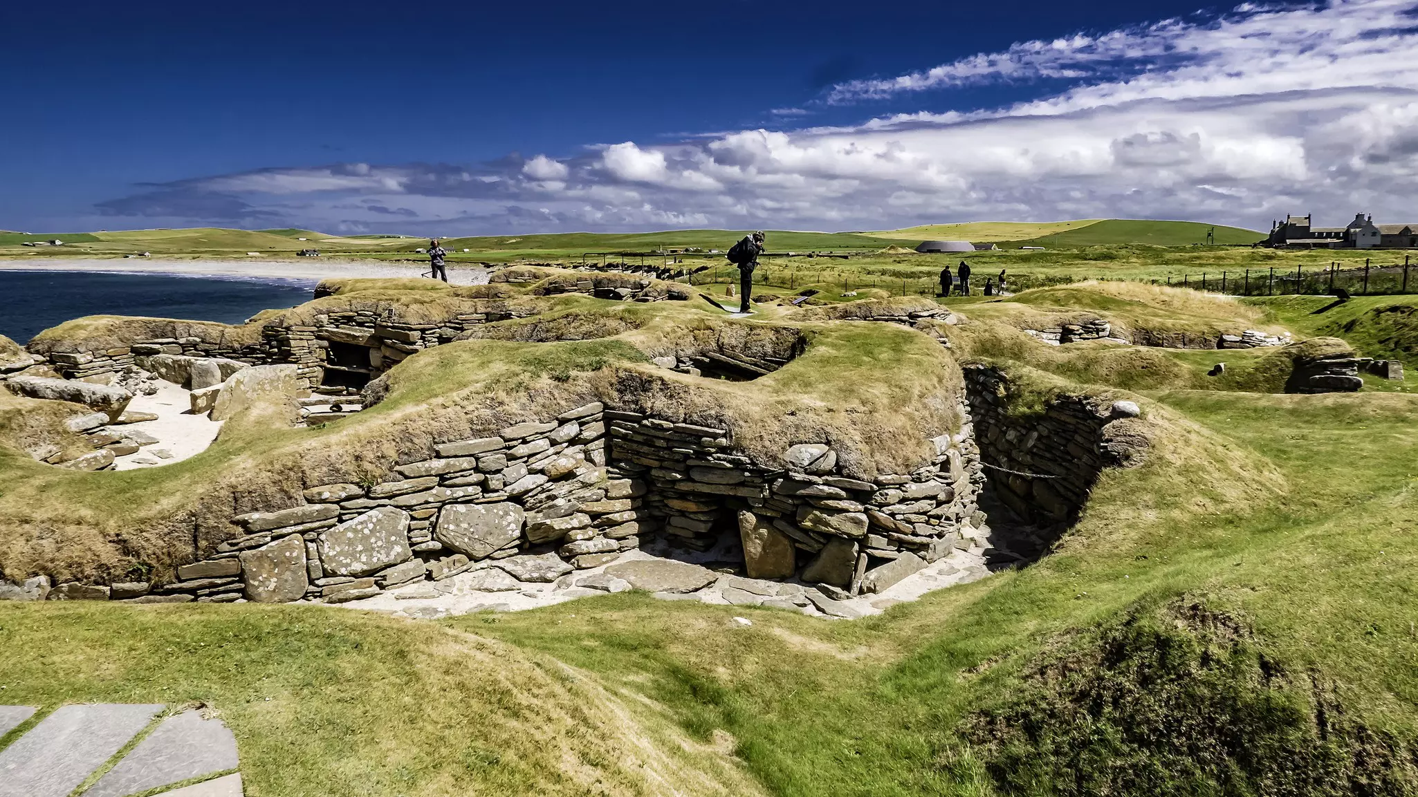 People exploring the ruins of Skara Brae, Orkney, Scotland.