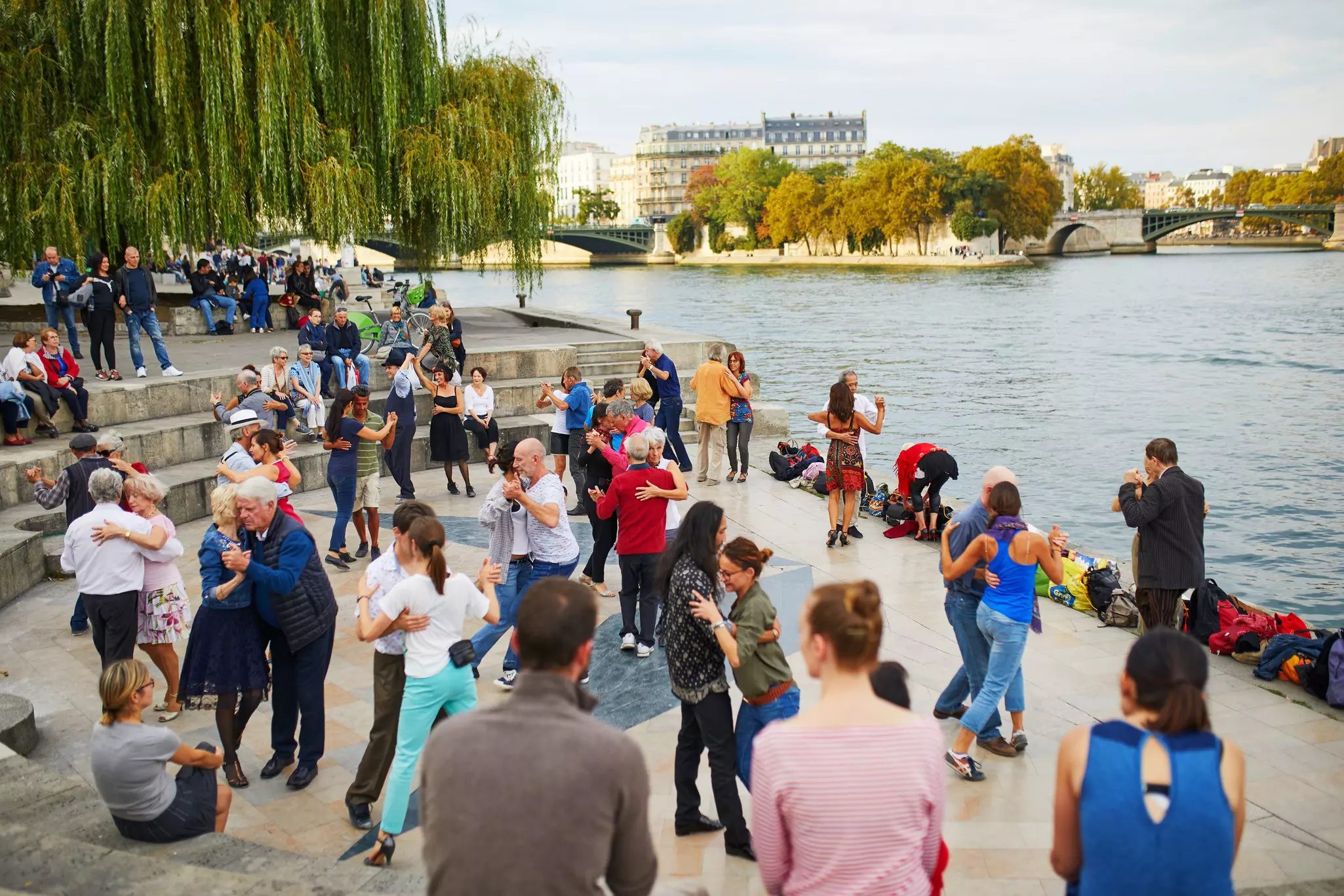 People partner dancing on the Seine embankment in Paris, France