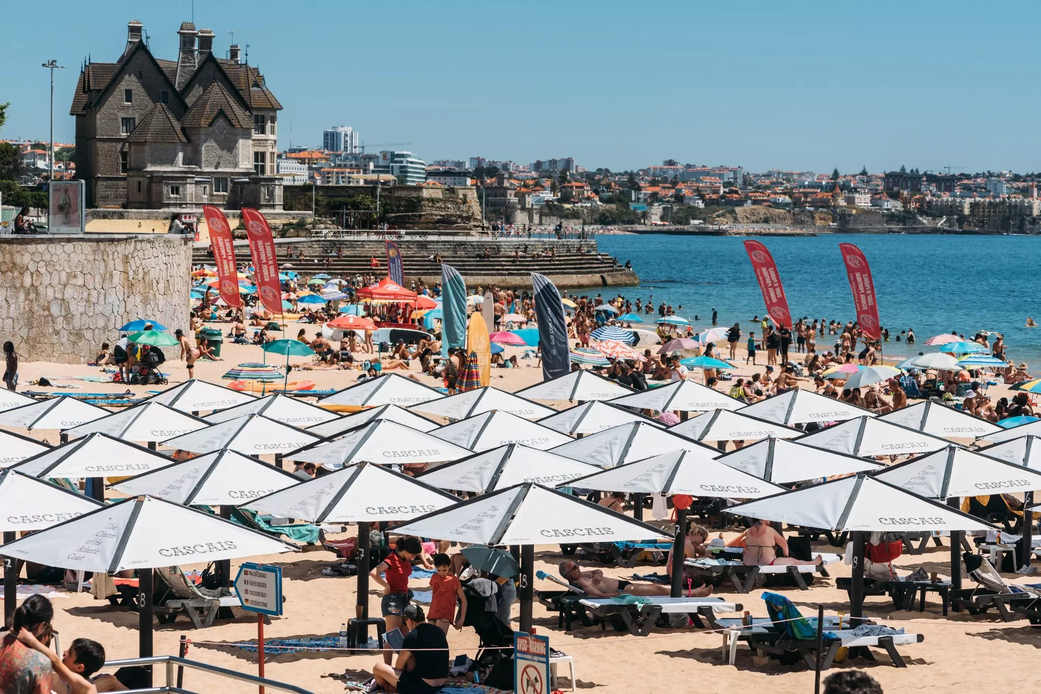 A city beach with white umbrellas and sun loungers is pictured in summer.
