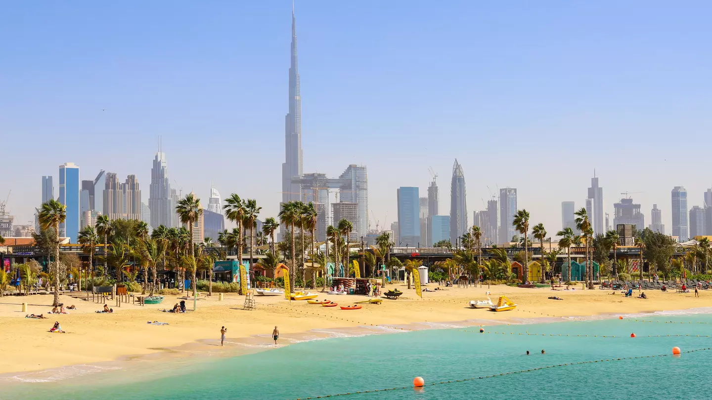 People at La Mer Beach with skyscrapers of Dubai in the background