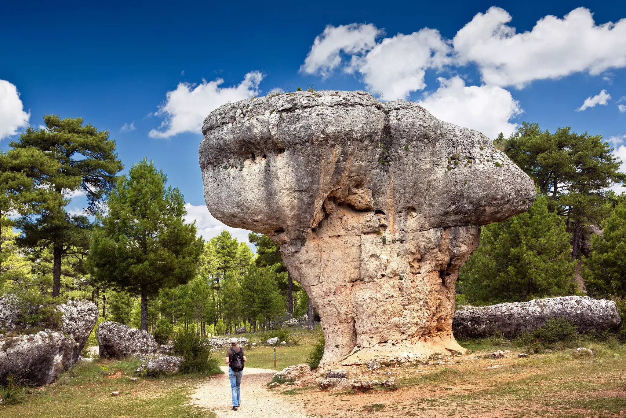 Landscape with man observing the karst rock formations of Ciudad Encantada (enchanted city) at the Serrania de Cuenca natural park, near the city of Cuenca in Spain.