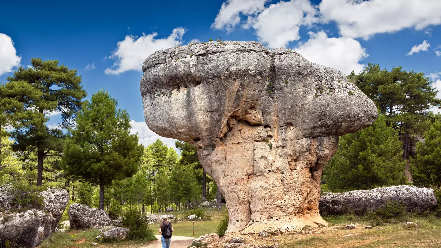 Landscape with man observing the karst rock formations of Ciudad Encantada (enchanted city) at the Serrania de Cuenca natural park, near the city of Cuenca in Spain.