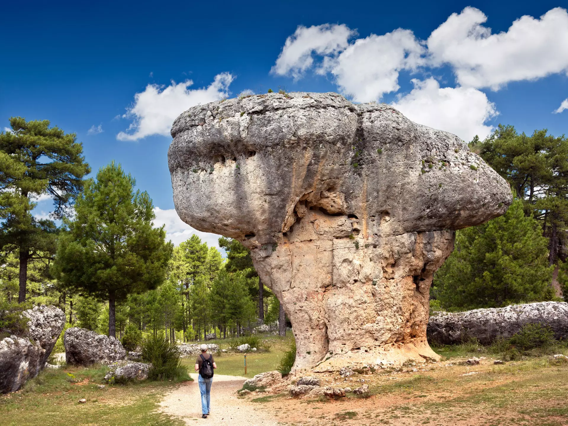 Landscape with man observing the karst rock formations of Ciudad Encantada (enchanted city) at the Serrania de Cuenca natural park, near the city of Cuenca in Spain.