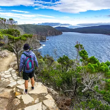 Man hiking toward Fortescue Bay along the coast.