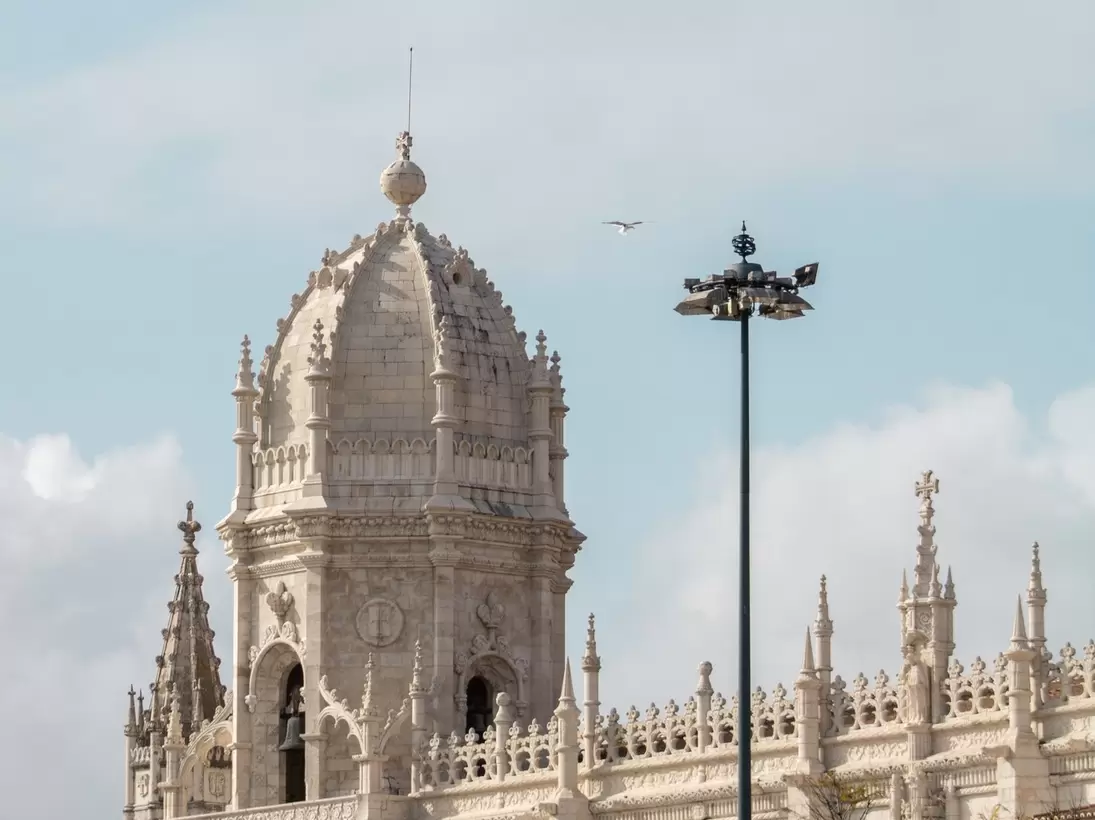 The exterior of the Mosteiro dos Jerónimos on a cloudy day in Lisbon, Portugal.