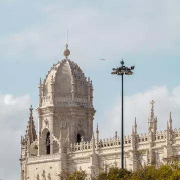 The exterior of the Mosteiro dos Jerónimos on a cloudy day in Lisbon, Portugal.