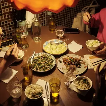 Table of Taiwanese dishes with diners around it in a thirdfloor bar and restaurant in TAIPEI CITY, TAIWAN