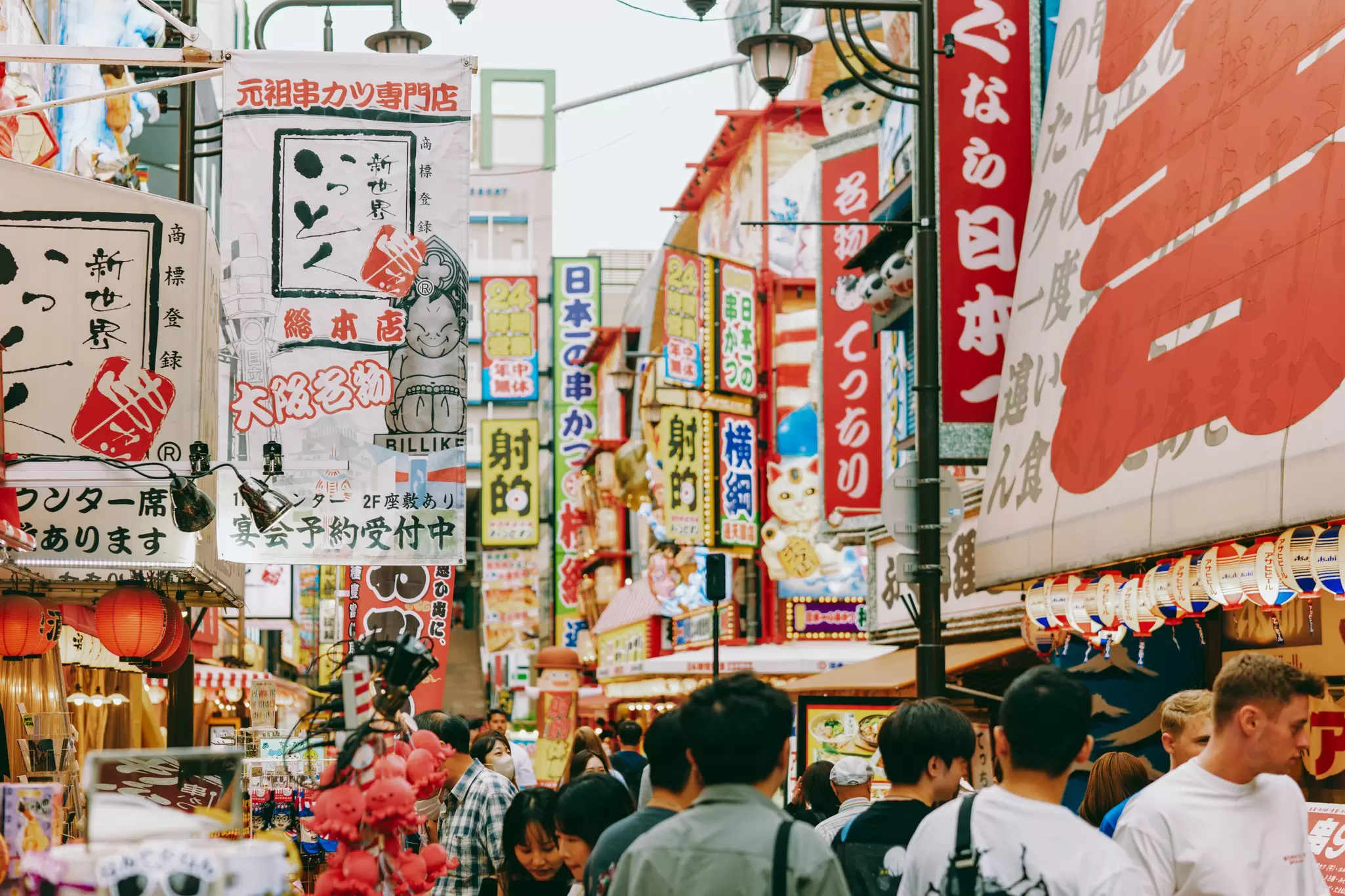 Brightly colored Japanese signs line a street in Osaka.